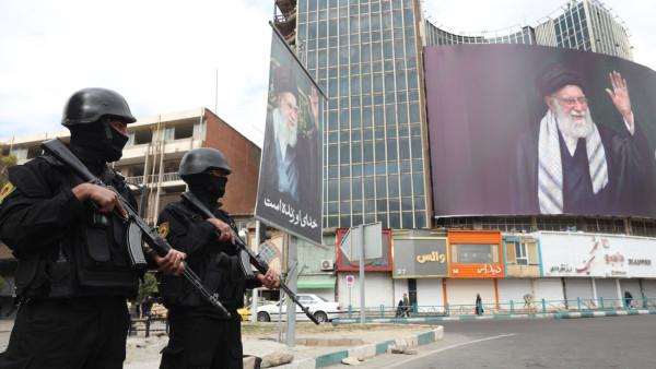 Forças de segurança iranianas montam guarda ao lado do enorme outdoor do líder supremo iraniano, aiatolá Ali Khamenei, na Praça Valiasr, em Teerão, Irão, 2 de março de 2026. 