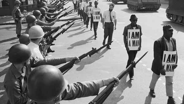 Memphis, 1968. A Guarda Nacional bloqueia uma rua enquanto os manifestantes negros trazem um cartaz a dizer "eu sou um homem". Foto de bswise/Flickr.