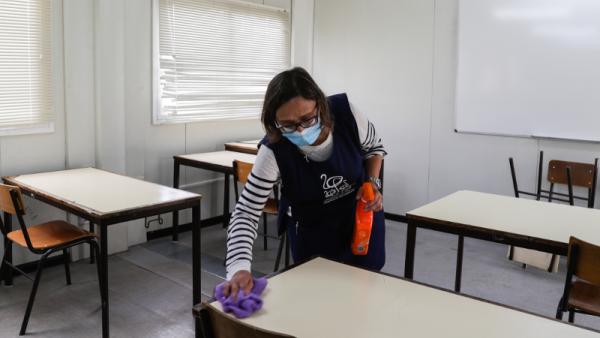 Uma funcionária limpa uma sala de aula já disposta para o distanciamento dos alunos na Escola Secundária João de Barros, em Corroios, 11 de maio de 2020- Foto de Tiago Petinga/Lusa