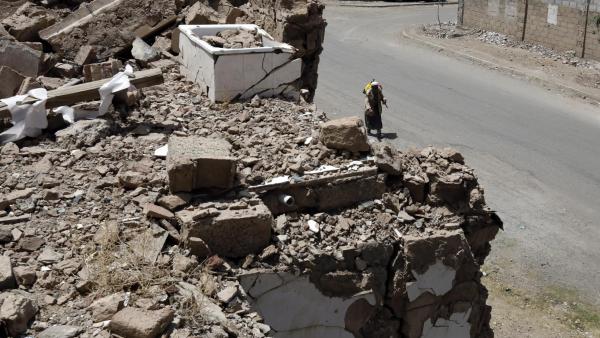 No dia em que passavam cinco anos do início da guerra no Iémen, um homem passeia junto a destroços em Sanaa. Foto de YAHYA ARHAB/EPA/LUSA.