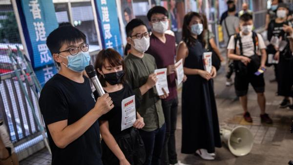 Membros do partido Demosisto distribuem panfletos contra a nova Lei de Segurança Nacional chinesa esta sexta-feira. Foto de Jerome Favre/EPA/Lusa.