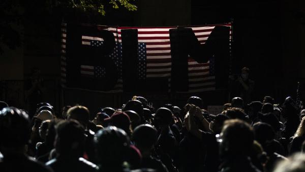 Manifestantes à porta do edifício federal onde tem havido confrontos com os agentes enviados por Trump. Foto de ETIENNE LAURENT/EPA/Lusa.