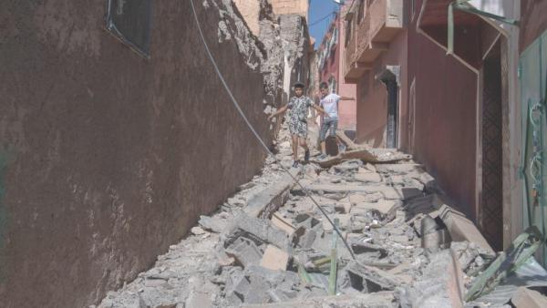 Crianças caminham sobe os escombros de edifícios destruídos pelo sismo em Marraquexe.