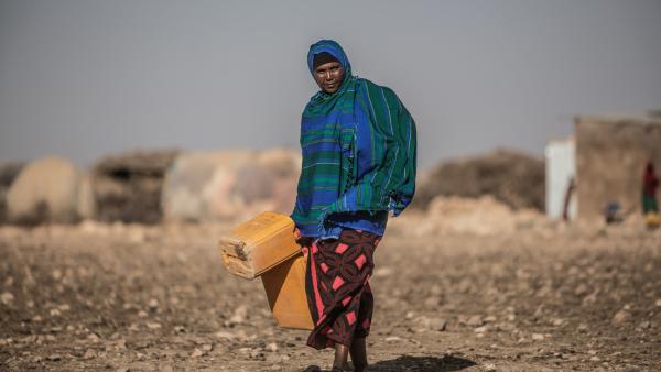 Mulher africana carrega bidões de água. Foto da Oxfam no Twitter.