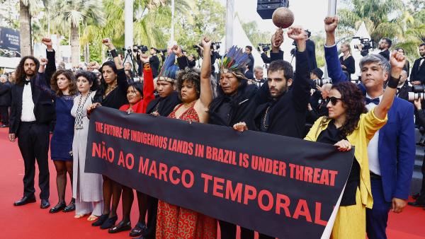 Protesto no tapete vermelho do Festival de Cannes com a exibição de um cartaz onde se podia ler: Não ao marco temporal - the future of indigenous lands in Brazil is under threat (o futuro das terras indígenas brasileiras está ameaçado).