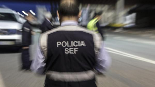 Inspetor do SEF de costas. Foto desfocada.