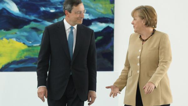 Na zona euro, este aparente paradoxo da política monetária é a expressão de problemas mais profundos - Foto Mario Draghi e Angela Merkel