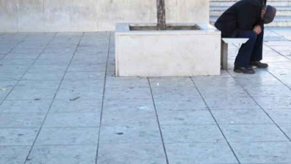 Pessoa isolada com a cabeça encostada nas suas próprias pernas.