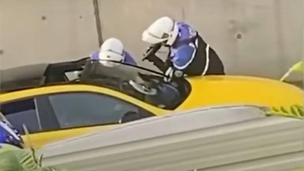 Dois polícias junto ao carro onde circulava Nahel. Um deles aponta a arma ao condutor, de 17 anos.