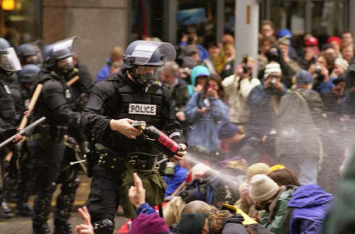 Polícia dispara gás lacrimogéneo sobre manifestantes sentados. Seattle, 30 de novembro de 1999.