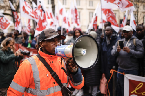 Manifestantes contra a lei de imigração francesa esta segunda-feira em frente ao parlamento. Foto de YOAN VALAT/EPA/Lusa.