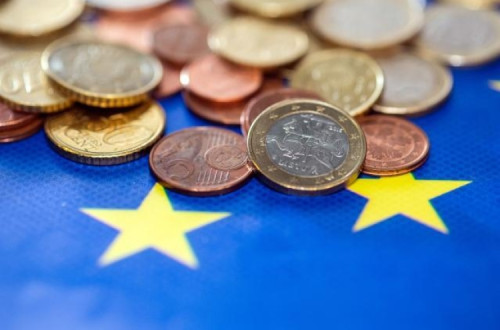 Moedas de euro sobre a bandeira europeia.