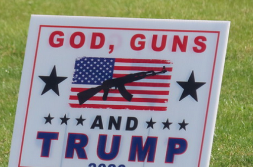 Cartaz em que está escrito "armas, Deus e Trump".