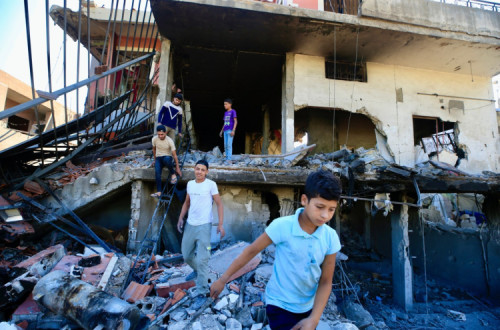 Habitantes procuram os seus pertences numa casa bombardeada