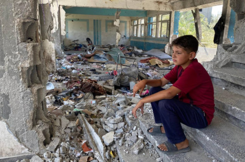 Rapaz numa escola destruída em Nuseirat, na Faixa de Gaza.