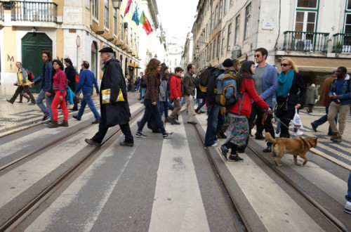 Pessoas atravessam passadeira na baixa de Lisboa