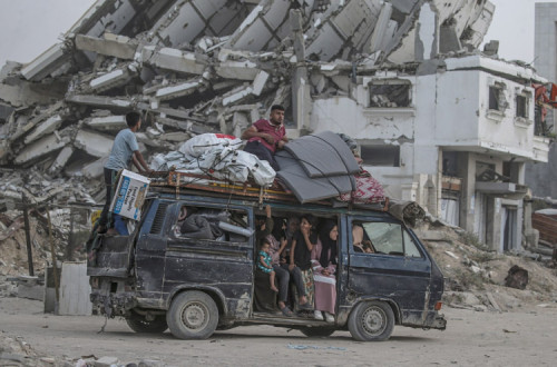 Palestinianos deslocados internamente saem com os seus pertences após uma ordem de evacuação emitida pelo exército israelita do norte da Faixa de Gaza, na Cidade de Gaza esta segnda-feira.