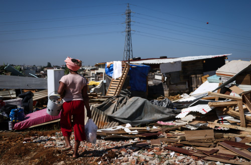 Uma moradora passa por destroços das habitações demolidas no Bairro do Talude Militar em Loures.