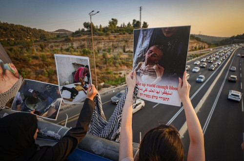 Israelitas protestam contra a guerra e a crise humanitária em Gaza, numa ponte rodoviária perto de Jerusalém, em 15 de agosto de 2025