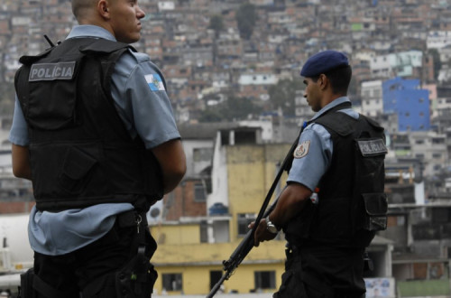 Polícias armados junto a favela.