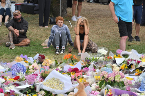 Pessoas em luto num memorial improvisado na praia de Bondi, em Sydney, 