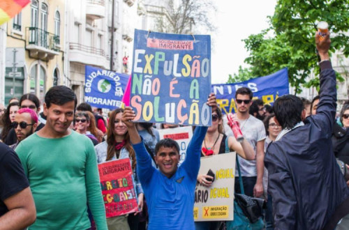 imigrante com cartaz "Expulsão não é a solução"