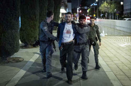Agentes da polícia detêm um manifestante numa manifestação contra a guerra de Israel com o Irão, na Praça Habima, em Telavive, a 28 de março de 2026.