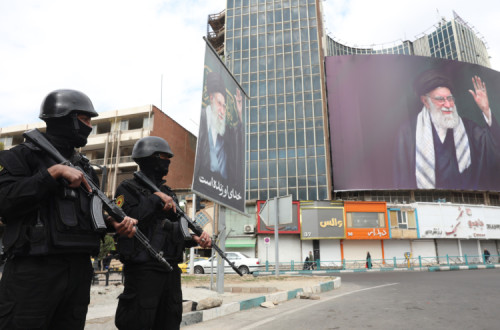 Forças de segurança iranianas montam guarda ao lado do enorme outdoor do líder supremo iraniano, aiatolá Ali Khamenei, na Praça Valiasr, em Teerão, Irão, 2 de março de 2026. 
