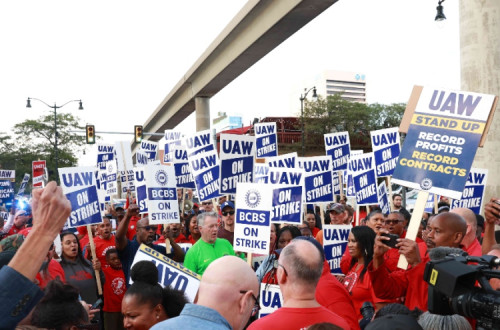 Trabalhadores com cartazes da UAW sobre a greve no setor dos automóveis. Foto do sindicato.