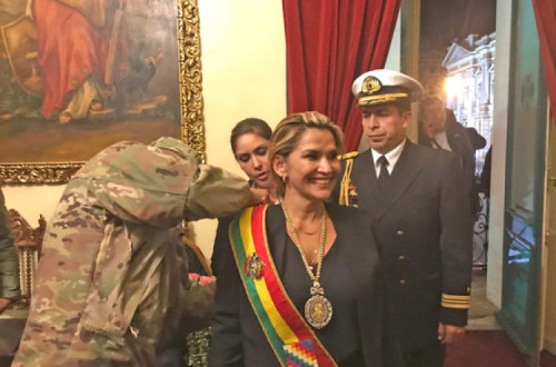 Jeanine Añez, auto-proclamada presidente da Bolívia, recebe a faixa presidencial das mãos dos militares.