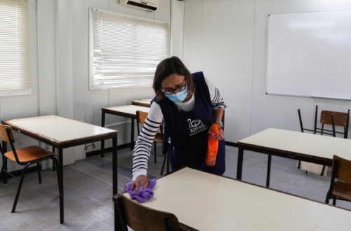 Uma funcionária limpa uma sala de aula já disposta para o distanciamento dos alunos na Escola Secundária João de Barros, em Corroios, 11 de maio de 2020- Foto de Tiago Petinga/Lusa