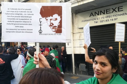 Manifestante transporta cartaz com uma citação de Matoub Lounès durante a marcha em Argel a 12 de abril de 2019. Foto de Jérôme Duval
