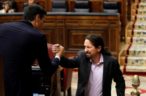 Pedro Sánchez e Pablo Iglesias cumprimentam-se durante o debate de investidura do governo espanhol. Janeiro de 2020.