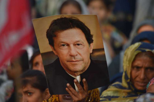 Apoiantes do ex-primeiro-ministro Imran Khan erguem cartaz com a sua fotografia.