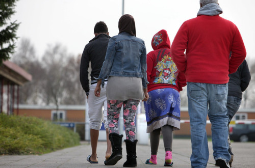 Pessoas caminham perto do Centro de Acolhimento de Refugiados de Ter Apel. Foto de Directie Voorlichting/Flickr.