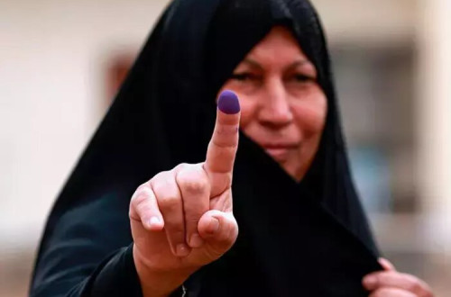 Uma mulher iraquiana mostra o dedo “pintado” como sinal de que votou nas eleições de 12 de Maio de 2018. Foto: fornecida pelo governo iraquiano e publicada em https://diyaruna.com
