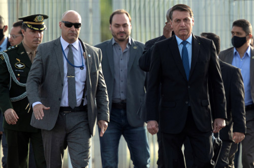 Jair Bolsonaro, à direita, com Carlos Bolsonaro, ao centro. Foto de Joedson Alves via EPA/Lusa.