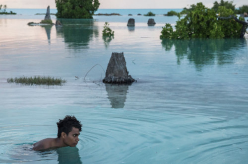 Os pequenos estados insulares do Pacífico estão extremamente preocupados com as alterações climáticas - Jovem de 16 anos nada numa área inundada em Aberao, Kiribati - Foto Sokhin/Unicef