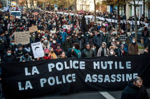 Manifestação em Paris contra a lei de “segurança global”, faixa com a palavra de ordem “Polícia mutila, Polícia Mata” - Foto de  Christophe Petit Tesson/Epa/Lusa