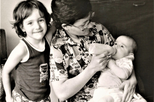 Maria Machado com a filha ao seu lado e o filho ao colo.