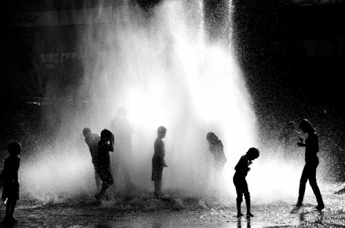 Miudos a brincar numa fonte em Portland, EUA.