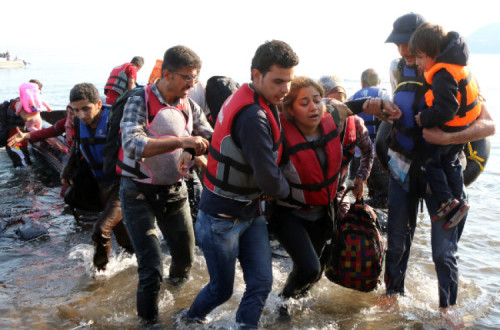 Refugiados sírios vindos da Turquia num barco de borracha desembarcam na ilha grega de Lesbos. Foto EPA/KATIA CHRISTODOULOU