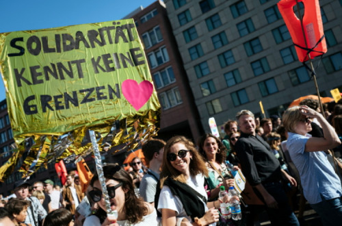 “Solidariedade não conhece fronteiras” pode ler-se no cartaz de uma participante na manifestação realizada neste sábado em Berlim – Foto de Kamil Zihnioglu/Epa/Lusa 