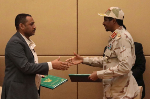 O vice-presidente do Conselho Militar de Transição, Mohamed Hamdan Dagalo e o líder do movimento de protesto Ahmad al-Rabiah apertam as mãos depois de assinarem a Declaração Constitucional em Cartum, 4 de agosto. Foto de Marwan Ali, EPA-LUSA