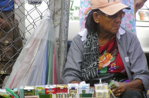 Vendedora em Manila oferece maços com 20 cigarros por menos de um dólar. Foto de Kara Santos/IPS
