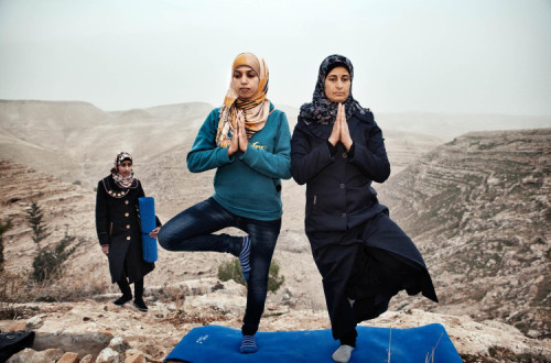 Hayat (à esquerda) ensina yoga às residentes da sua aldeia, Zataara, nos arredores de Bethelehem, na Cisjordânia. Foto de Tanya Habjouqa/ Panos Pictures.