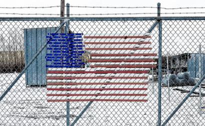 Bandeira americana numa vedação de arame farpado. Foto de Glen Zazove/Flickr.