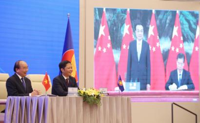 Primeiro-Ministro do Vietname e o seu ministro da Indústria e Comércio durante a cerimónia virtual de assinatura do acordo comercial RCEP. Foto de LUONG THAI LINH/EPA/Lusa.