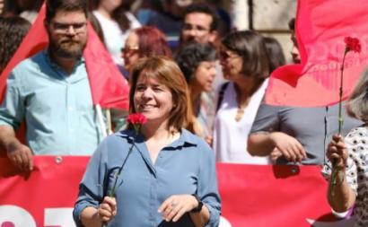 Catarina Martins numa manifestação com um cravo vermelho na mão.