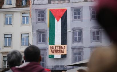 Bandeirão pendurado num edifício onde se lê Palestina Vencerá.